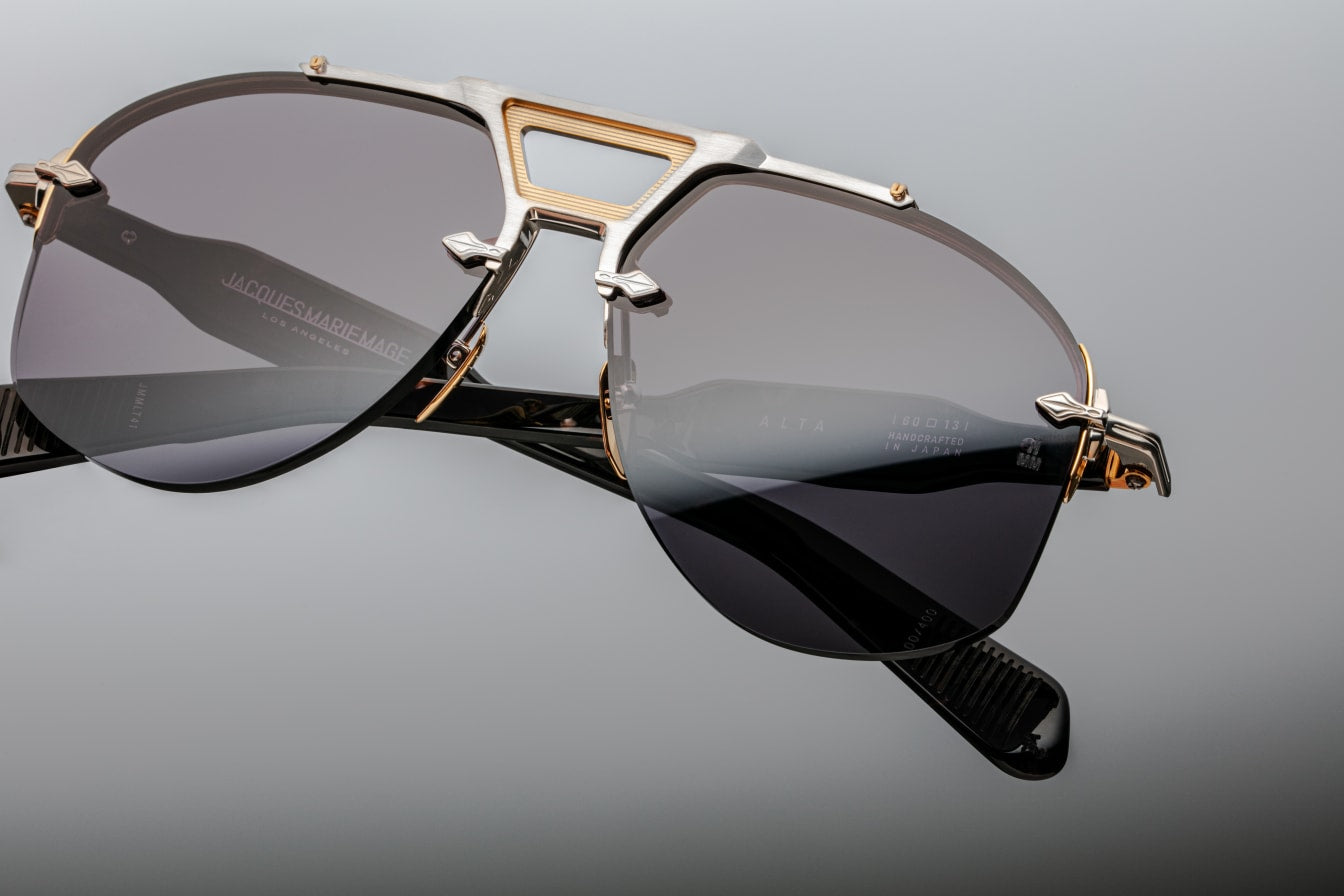 Aviators with attitude, the Alta is an astounding addition to the Rimless Series features dual-tone precious metal details and sculptural acetate temples with wire core embellishments.
SILVER 100% BETA TITANIUM FRAME WITH DARK GOLD ACCENTS, BLACK CURED CELLULOSE ACETATE TEMPLES AND GREY LENSES