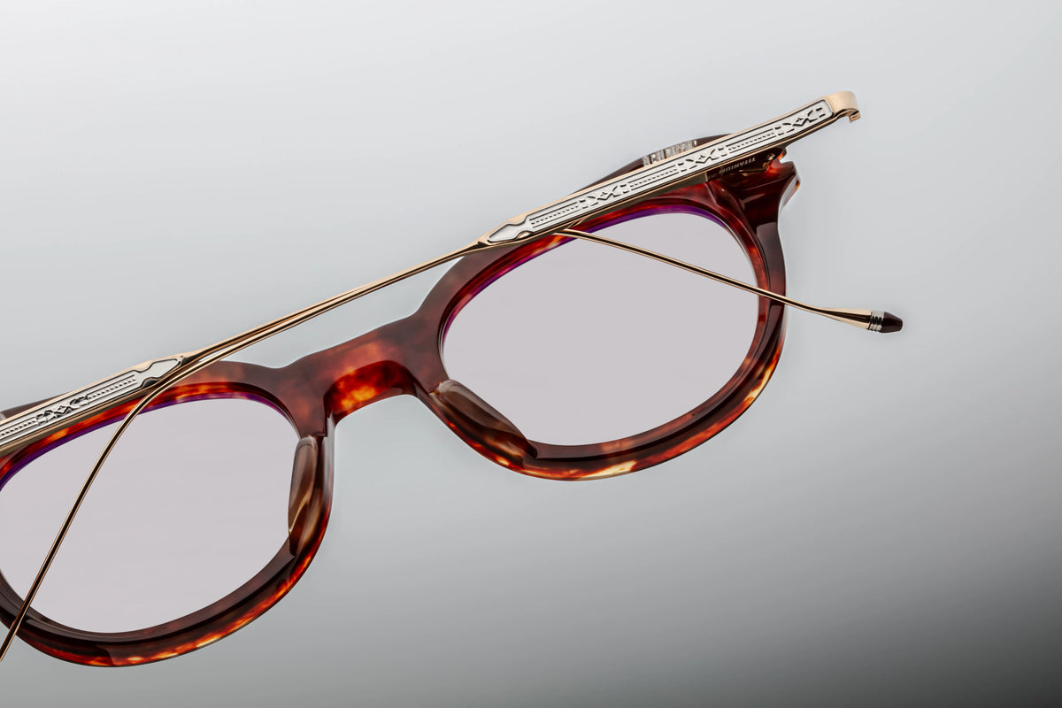 Back view of the Jacques Marie Mage Hisao Breccia glasses with folded temples, available at Wink Optometrists. The perspective highlights the inner sculpted acetate front, gold-tone hardware, and the sleek profile of the folded gold titanium arms.
