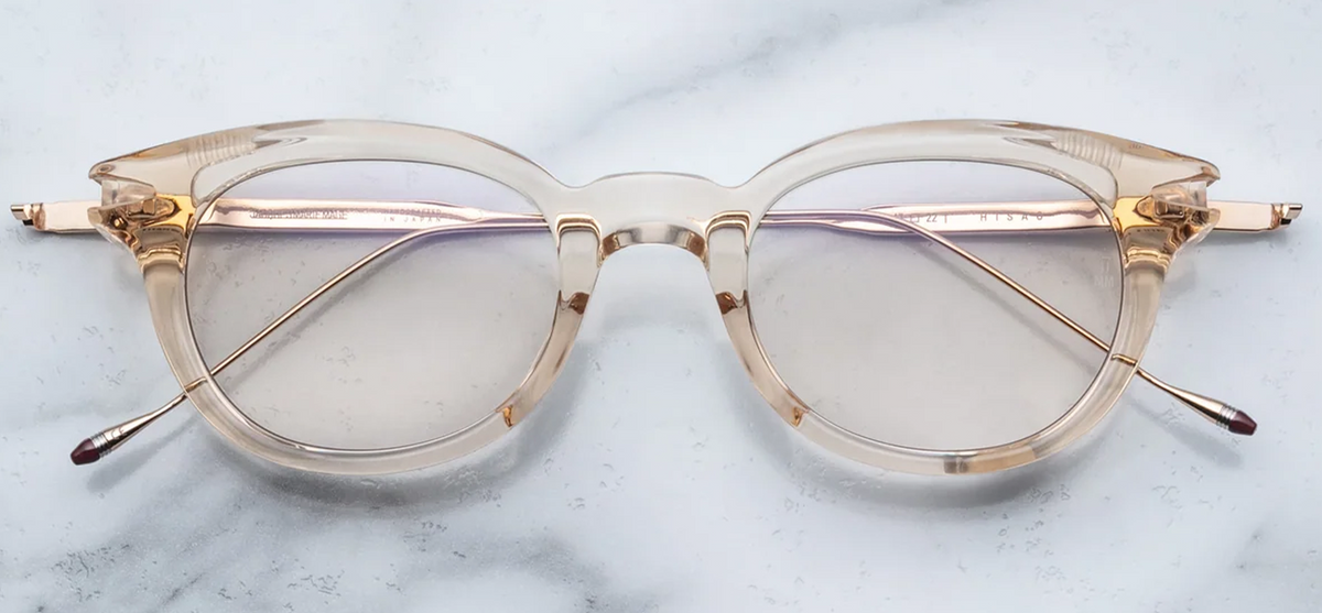 Front view of the Jacques Marie Mage Hisao glasses in Pearl. The frames feature a translucent, crystal-clear 12mm cured cellulose acetate front block shaped in a balanced, rounded Panto silhouette. The clear acetate cleanly reveals the inner construction, anchored at the outer upper corners by signature sterling silver arrowhead front pins, and paired with clear optical demonstration lenses