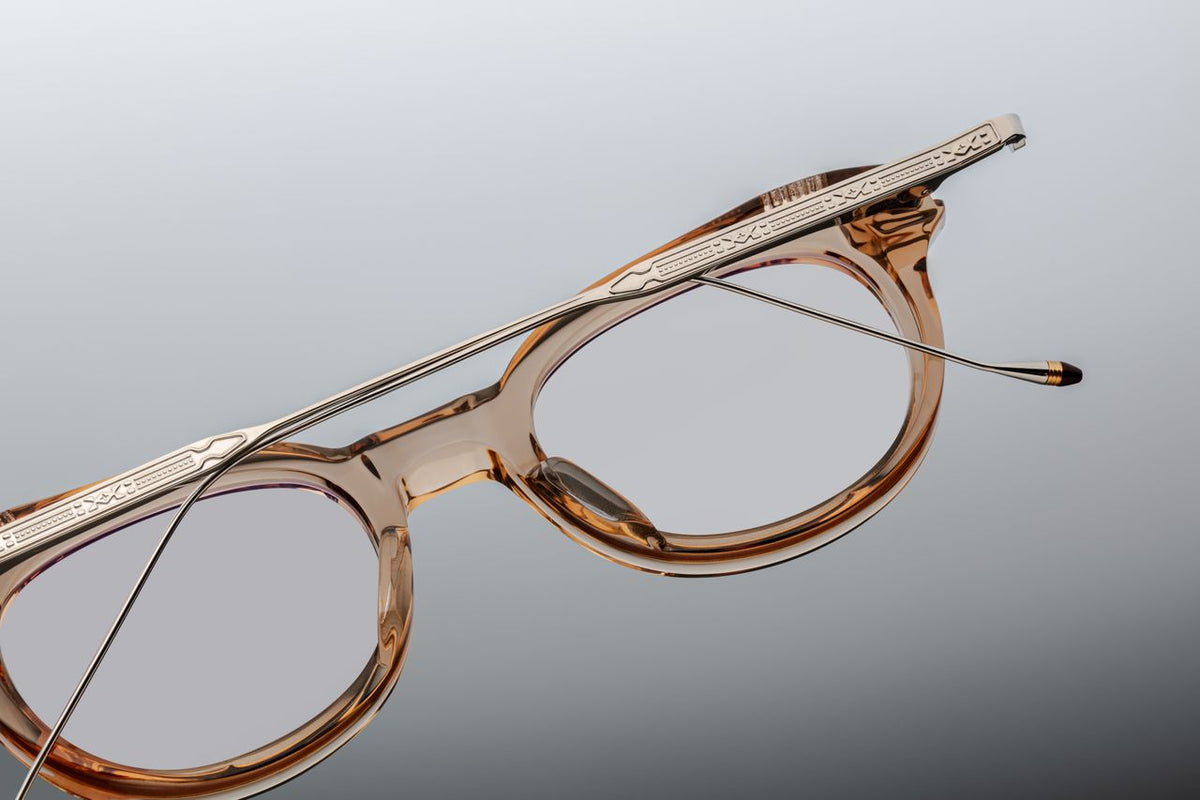 Back view of the Jacques Marie Mage Hisao Sand glasses with folded temples, available at Wink Optometrists. The perspective displays the inner clear tan acetate styling paired with folded silver titanium arms