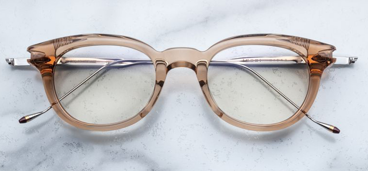 Front view of Jacques Marie Mage Hisao eyeglasses in Sand, available at Wink Optometrists. The oval-shaped frame features a lightweight, translucent tan cured cellulose acetate front with a keyhole bridge