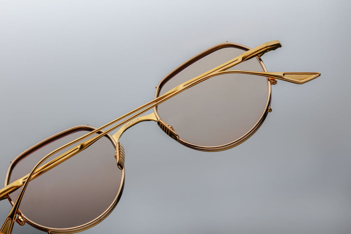 Back view of the Jacques Marie Mage Hartana Gold glasses with folded temples, available at Wink Optometrists. The image showcases the sleek rear profile of the gold titanium construction, the inner silver back eyerims, and the cleanly folded metal arms.