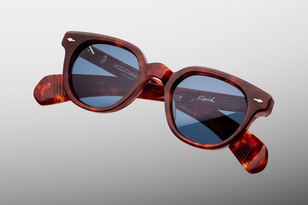 Top-down angle of the Stanley Kubrick 1948 Breccia glasses. Reveals the substantial thickness and premium beveled contours of the 10mm brown marbled acetate frame, the curve of the keyhole bridge, and the interior alignment of the temples tapering back