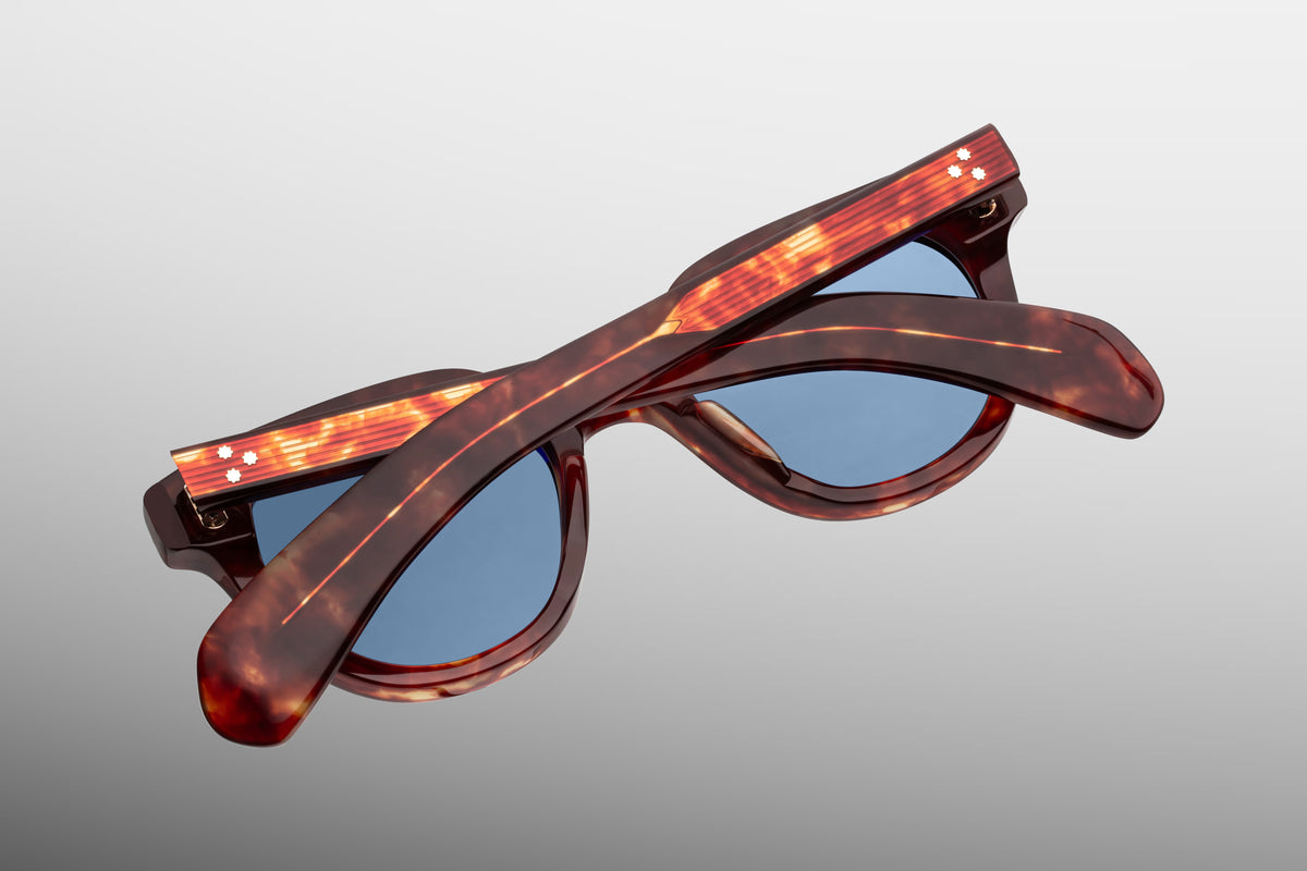  Rear perspective of the Jacques Marie Mage 1948 sunglasses in Breccia. Shows the inside architecture of the thick marbled brown frame, the inner surface of the category 3 Prussian blue lenses with anti-reflective coating, and the heavy-duty 7-barrel hinges