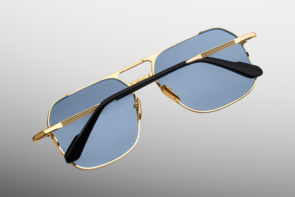  Rear perspective of the Jacques Marie Mage 1980 sunglasses in Ciel. Displays the reverse side of the golden aviator chassis, showing the hidden monoblock hinges, the inner silver foil hallmarks, and the backside anti-reflective treatment on the translucent serene blue lenses.