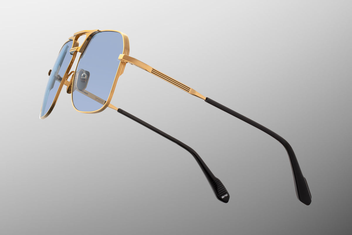 Close-up macro view of the hinge and rim details on the JMM 1980 Ciel frame. Features the premium moon gold beta titanium construction, intricate hairline border details precision-filled with black epoxy, and the clean, flush alignment of the custom internal hinge mechanism.