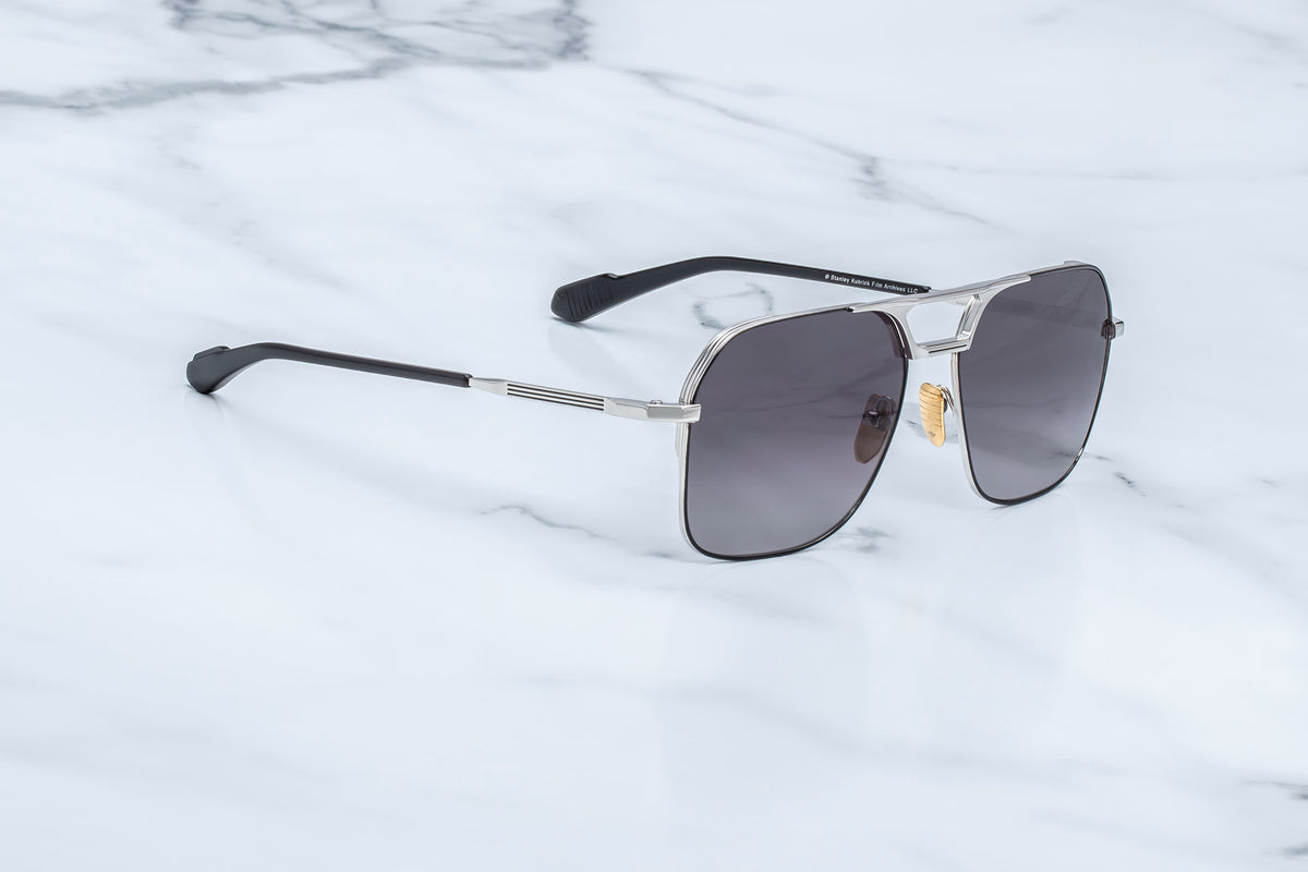 Full side profile of the Jacques Marie Mage 1980 Silver sunglasses. Displays the minimalist and architectural beta-titanium temple arms tapering back into dual-laminated black acetate temple tips, with the numbers "1980" engraved cleanly on the arm.