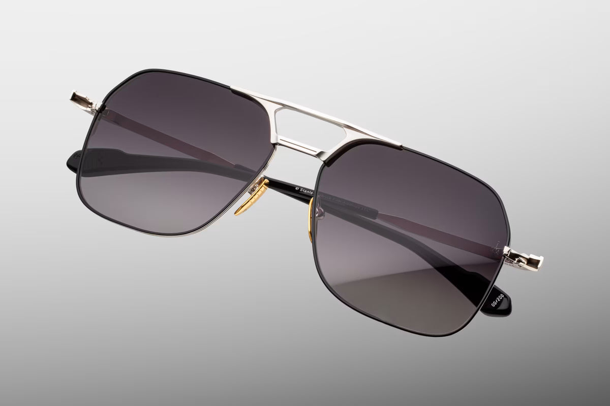 Top-down angle of the Stanley Kubrick 1980 Silver frame. Showcases the lightweight, 4mm custom wire rims, the precise angle of the sleek double titanium bridge, the polished luster gold nose pads, and the fluid curve of the temples extending rearward.