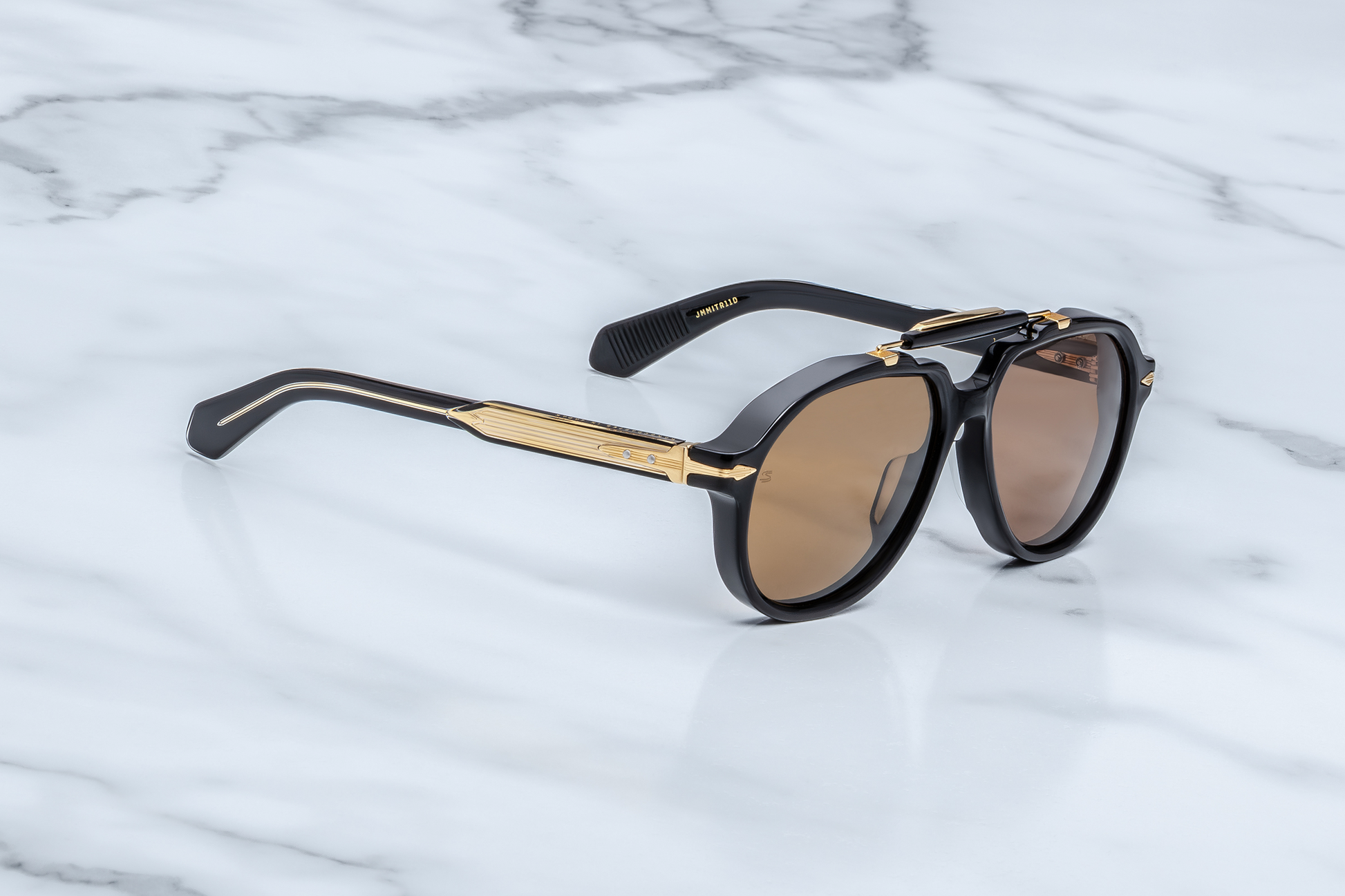Side profile of Jacques Marie Mage 1991 Eclipse 2 sunglasses showcasing the clear-over-black double-laminated acetate temple, exposed gold wire-core and silver arrowhead end-piece, available at WINK Optometrists