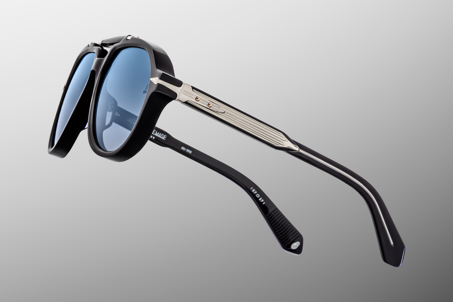 Detailed side close-up of Jacques Marie Mage Ayrton Senna 1991 Regal sunglasses showing the 5-barrel hinge assembly, refined hair-line engraving on the temple wire-core and black interior acetate, available at WINK Optometrists.