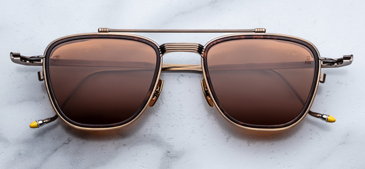 Front view of Jacques Marie Mage Ayrton Senna 1992 Antique Gold sunglasses showing bronze-hued beta-titanium pilot frame with matte agar acetate lens-rim inserts and warm pecan-brown crown-mineral lenses, available at WINK Optometrists