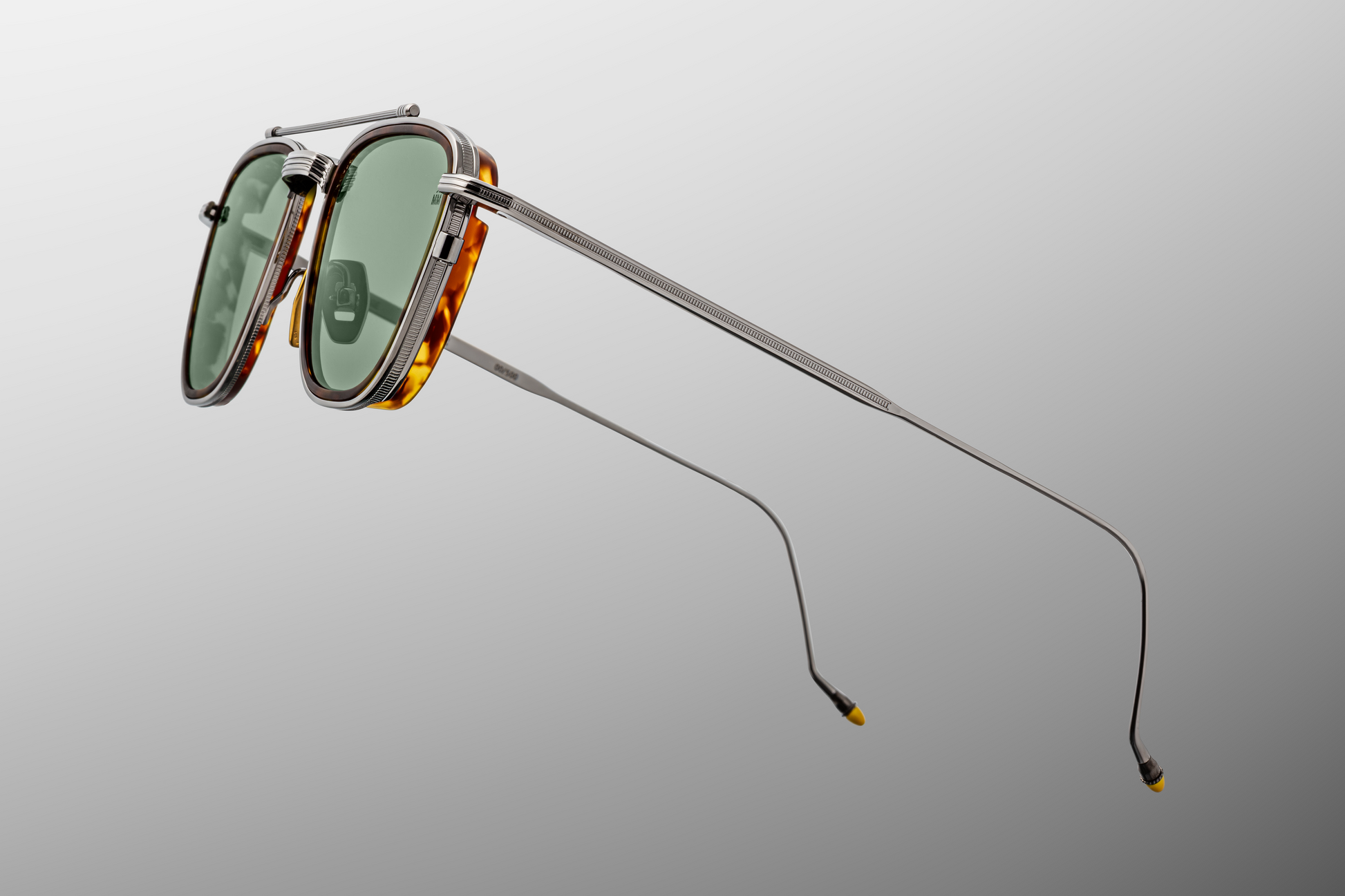 Detailed side close-up of Jacques Marie Mage 1992 Antique Silver sunglasses showing the monoblock hinge with refined hair-line engraving, beta-titanium temple core and signature epoxy-painted tip, available at WINK Optometrists.