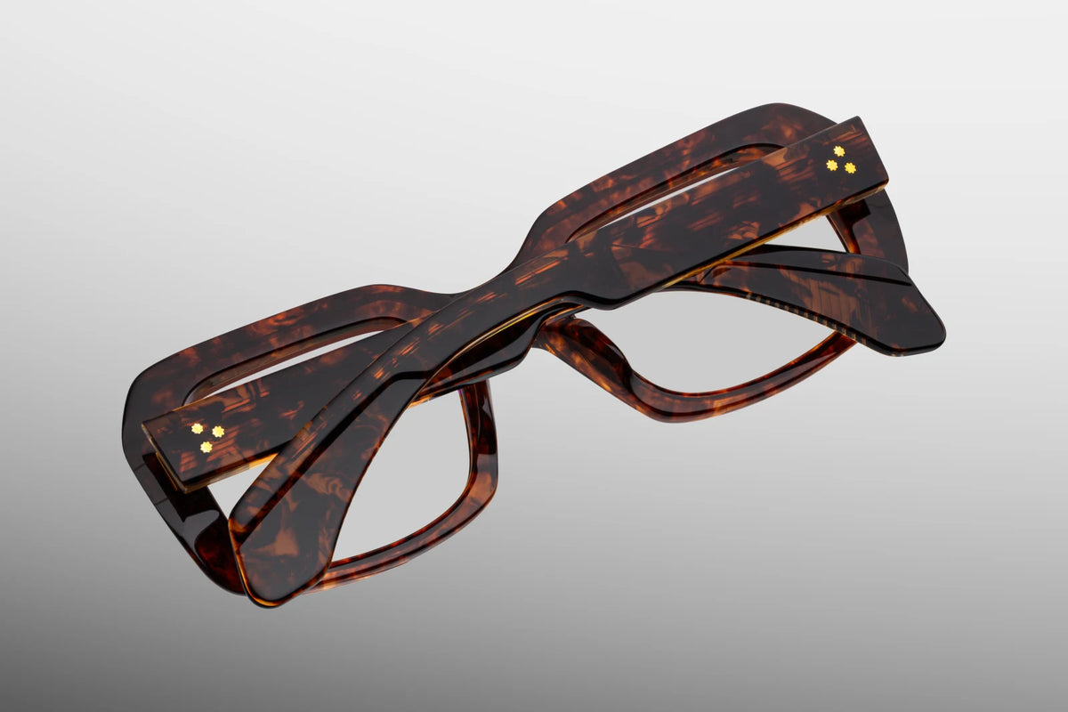 Close-up interior detail shot of the Jacques Marie Mage Aldo RX Argyle frame. The clear interior acetate layer exposes the custom-engraved metallic wire core and precious metal hardware. Text stamped in gold on the inner temple arm indicates the limited production batch details and the "Made in Japan" craftsmanship text. Available at WINK Optometrists.