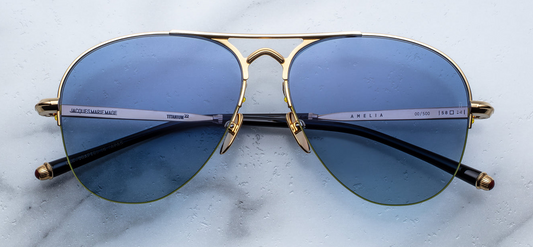 Front view of Jacques Marie Mage Amelia Gold semi-rimless designer aviator sunglasses with gold titanium frame and blue gradient lenses.