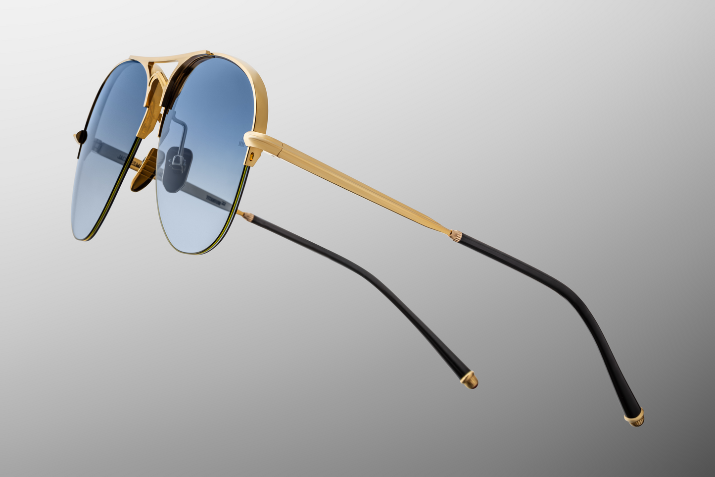 Close-up of Amelia Gold temple showing gold titanium with engraved detailing and Havana acetate tips in Art Deco design.