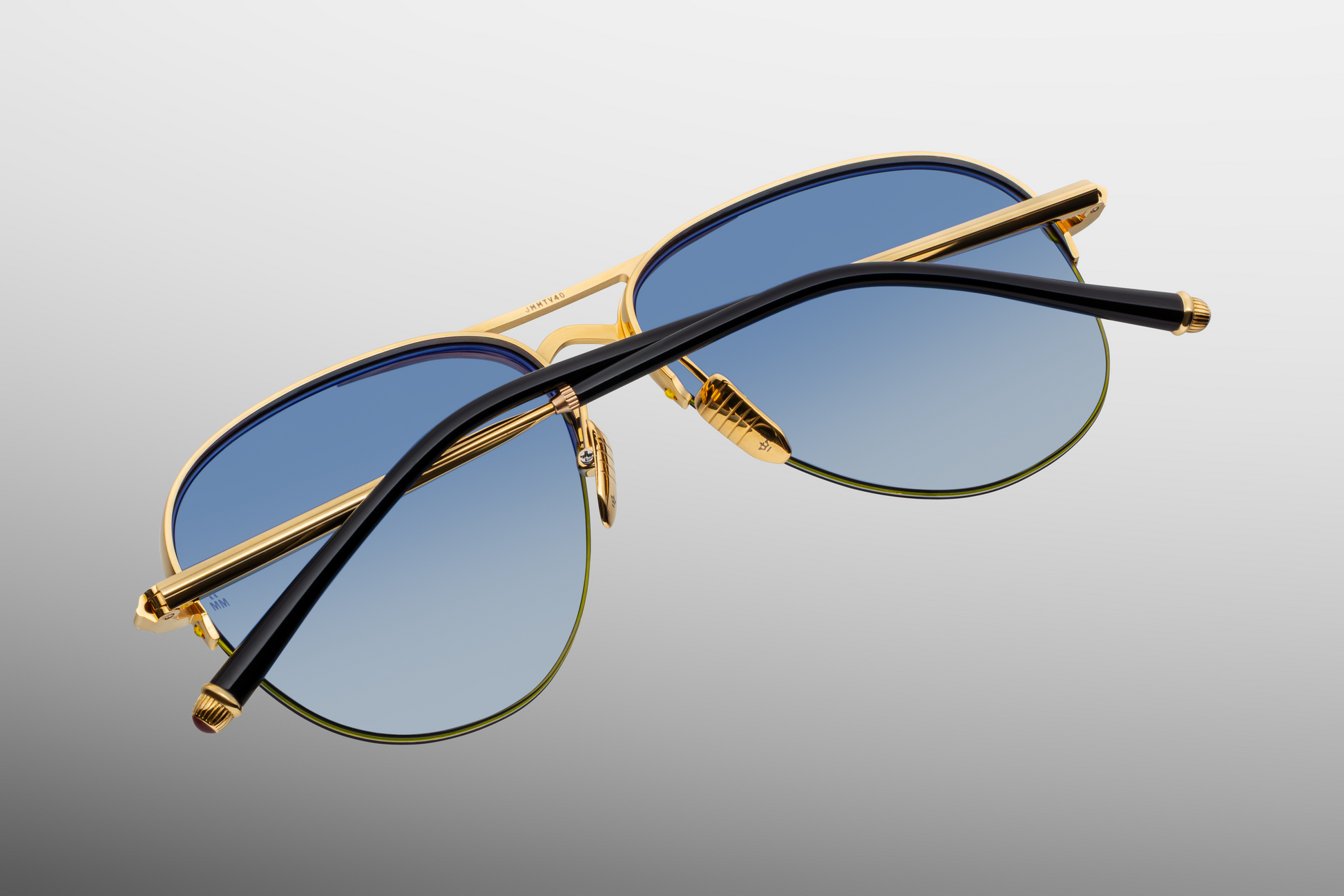 Folded Jacques Marie Mage Amelia Gold aviator sunglasses with ultra-light titanium frame and acetate temple tips.