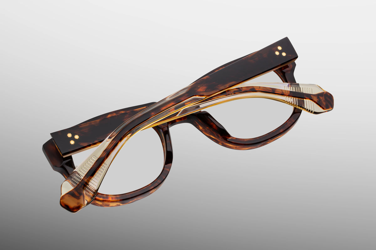 Close-up interior detail shot of the Jacques Marie Mage Amilcar RX Argyle frame architecture. The inner architecture reveals precious 18K dark gold hardware components alongside precision metalwork. Distinctive text foil-stamped in gold on the inner temple arm indicates its exclusive limited-edition batch number and the official "Handcrafted in Japan" production text. Available at WINK Optometrists