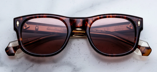 Front view of Jacques Marie Mage Amilcar sunglasses in Argyle Havana tortoise shell acetate, showcasing classic round lenses with a softly arched brow line, bronze lenses, and signature 18k dark gold arrowhead front pins