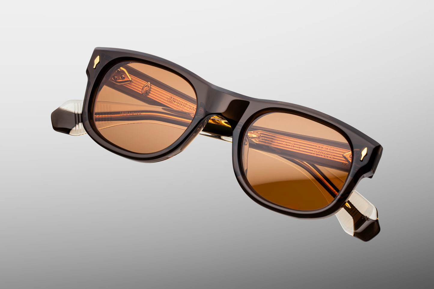 Top-down view of the JMM Amilcar London frame, revealing its engineered architecture, the integrated custom dark gold metal top bar crossing the brow line, and heavy-duty 7-barrel hinges.