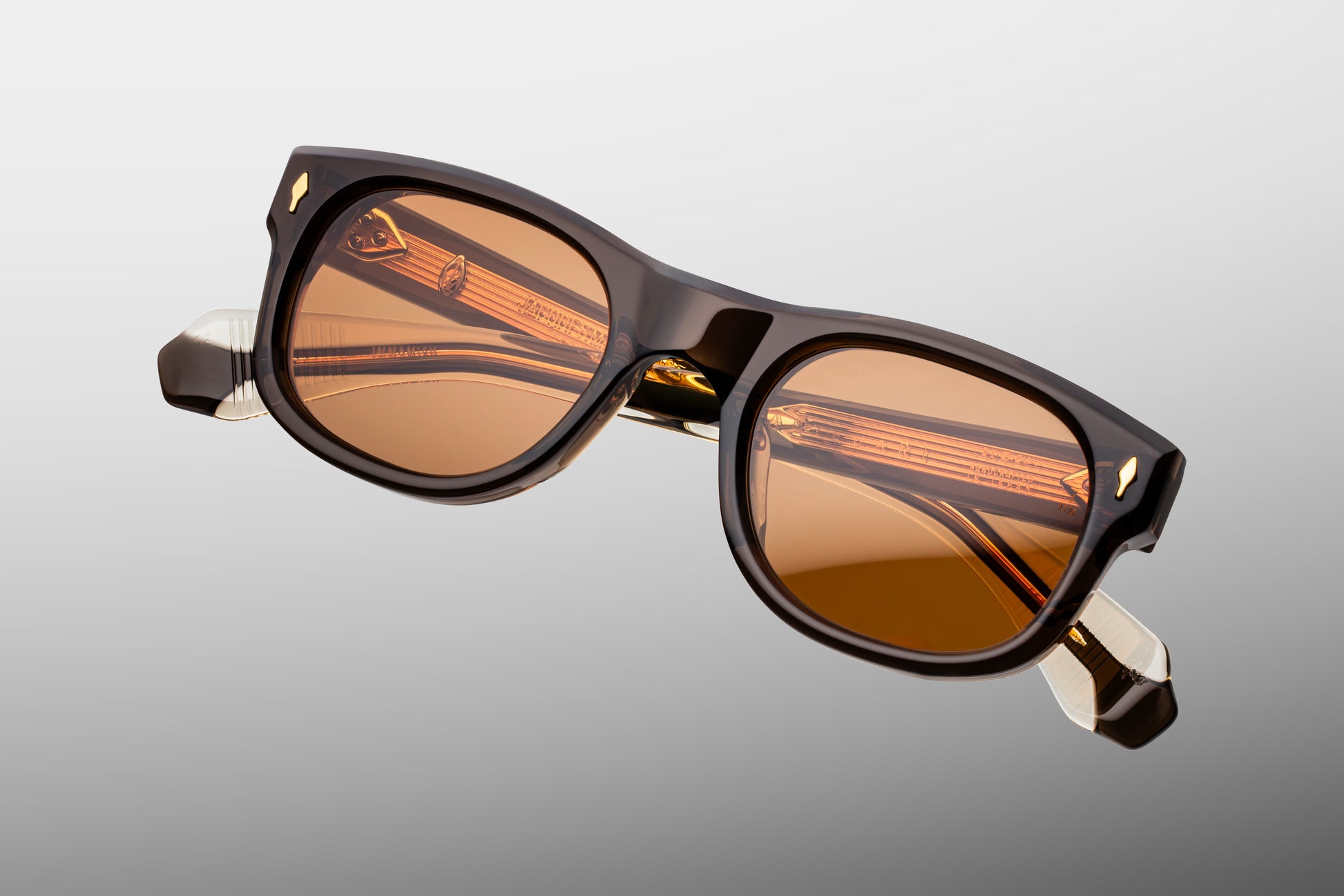 Top-down view of the JMM Amilcar London frame, revealing its engineered architecture, the integrated custom dark gold metal top bar crossing the brow line, and heavy-duty 7-barrel hinges.