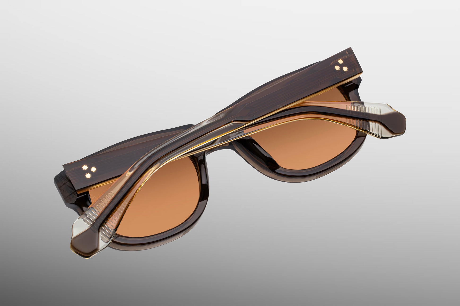 Rear perspective of the JMM Amilcar London temples, highlighting the inner curved ear bends where the deep brown exterior laminate transitions to reveal a clear beige interior lining and the internal dark gold wirecore tip.