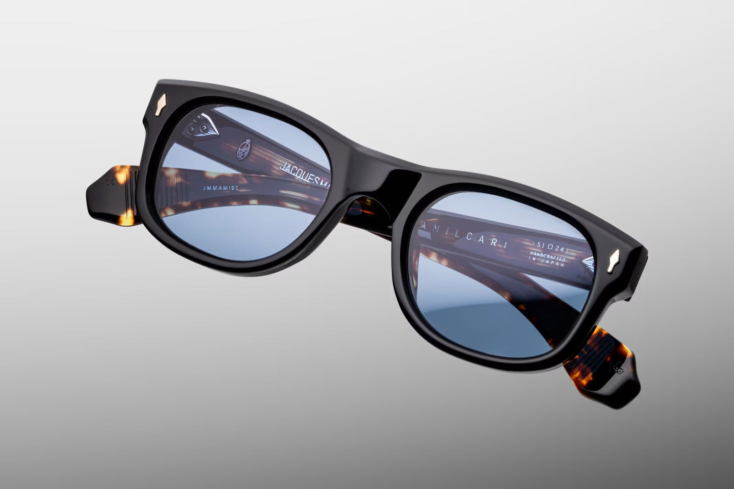 Top-down view of the JMM Amilcar Noir frame, revealing its engineered architecture, the custom dark gold metal top bar integrated into the brow line, and heavy-duty 7-barrel hinges