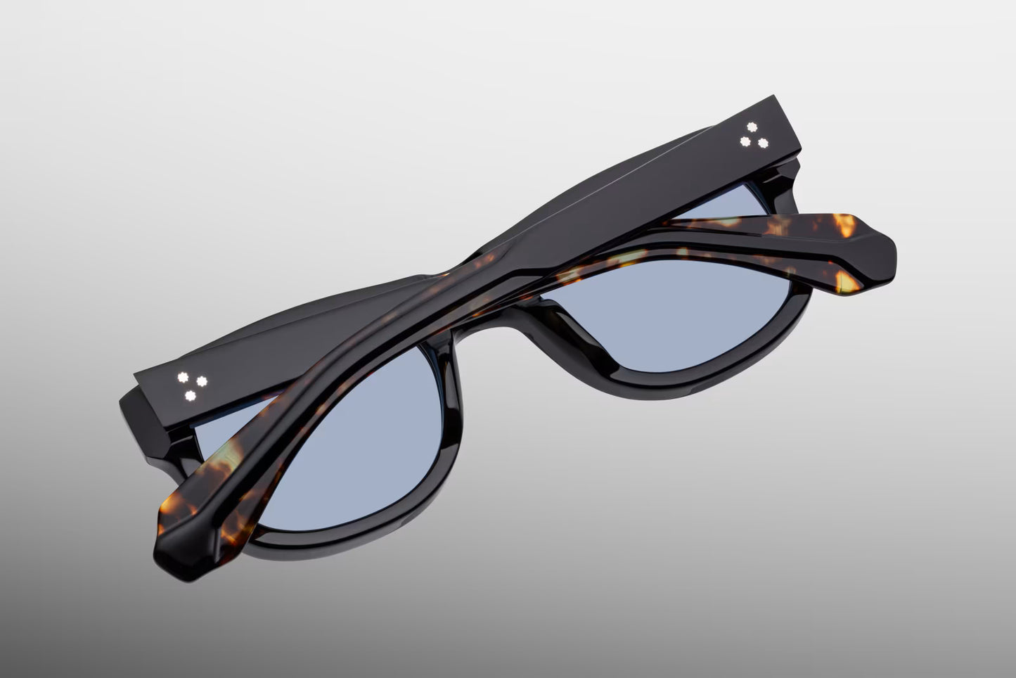 Rear perspective of the JMM Amilcar Noir temples, highlighting the curved ear bends where the glossy black exterior shifts to show the warm Havana interior laminate and the internal gold wirecore tip