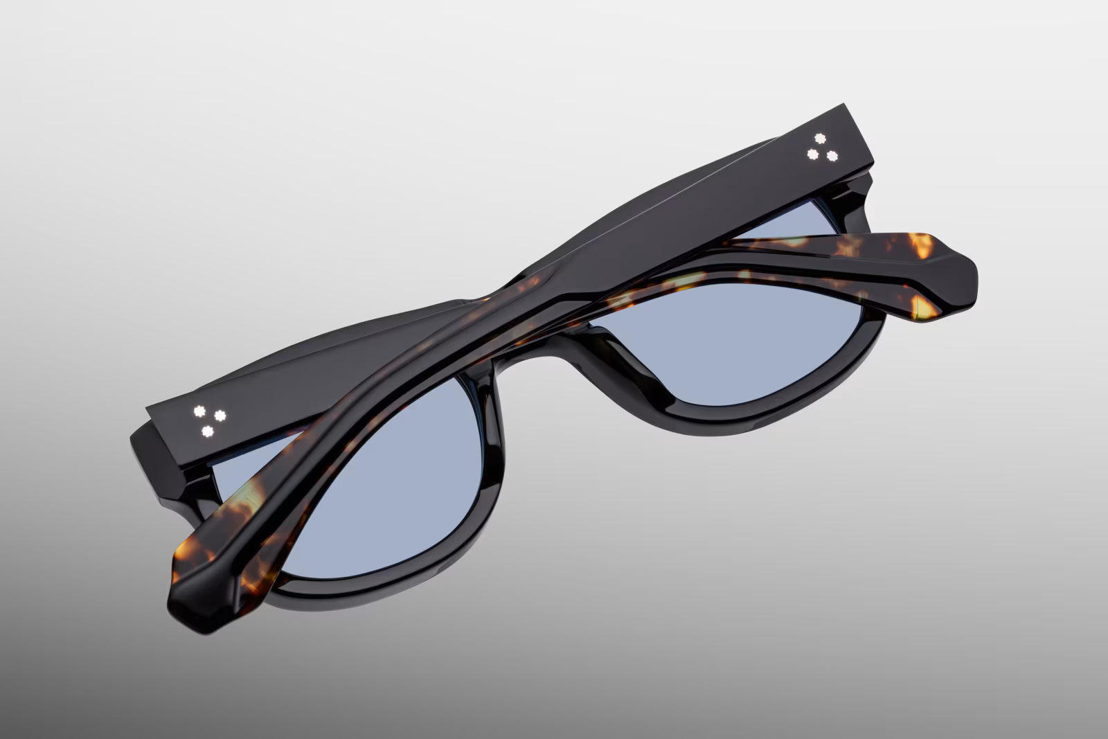 Rear perspective of the JMM Amilcar Noir temples, highlighting the curved ear bends where the glossy black exterior shifts to show the warm Havana interior laminate and the internal gold wirecore tip