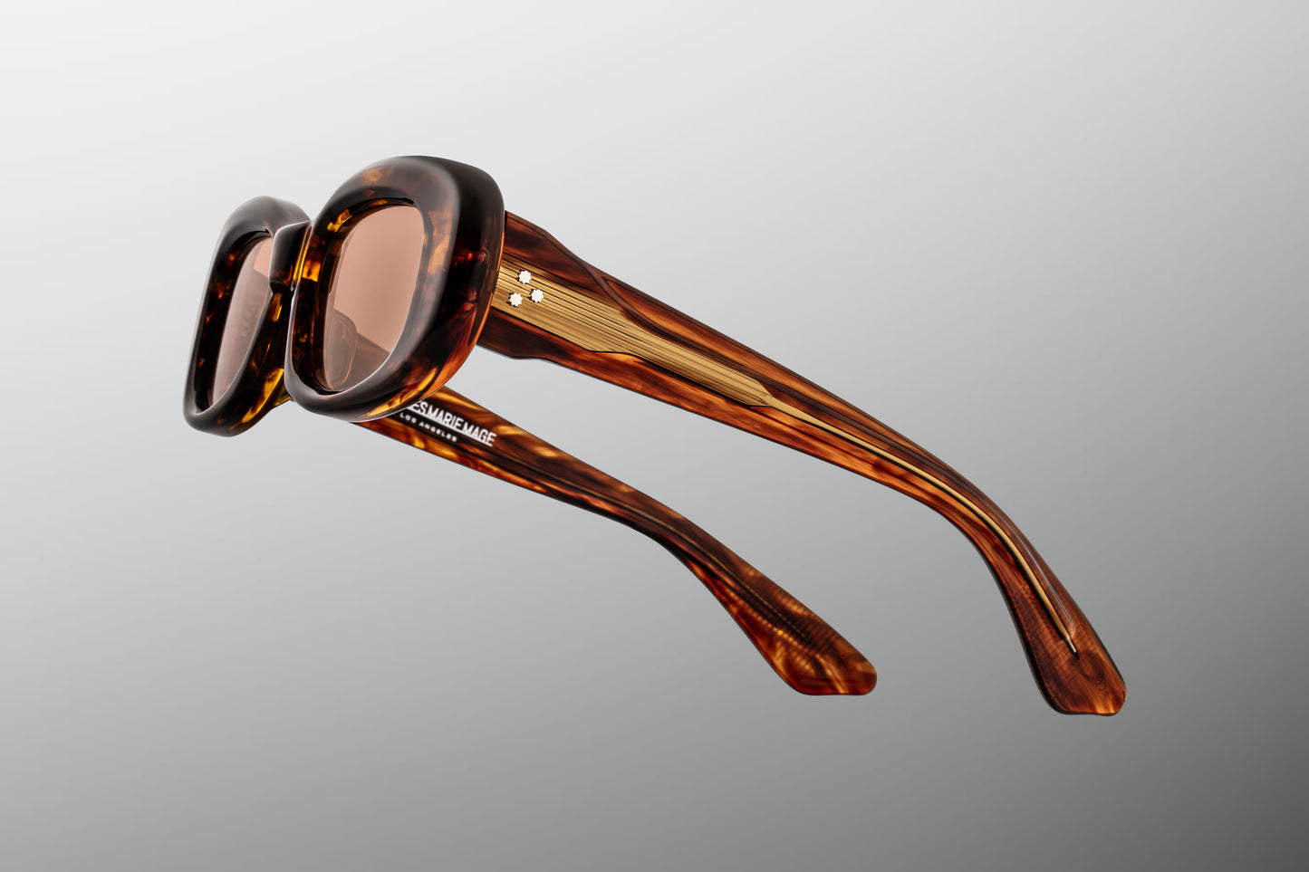 Close-up side detail of Jacques Marie Mage Ann Bourbon showing engraved wirecore, hinge construction and layered acetate temples
Macro side view of JMM Ann Bourbon highlighting premium gold hardware and precision craftsmanship