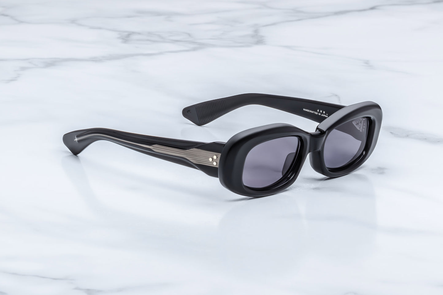 Jacques Marie Mage Ann Raven side view showing thick black acetate temples, exposed silver wirecore and sculpted profile
Side profile of JMM Ann Raven sunglasses highlighting 10mm acetate construction and premium hinge detailing