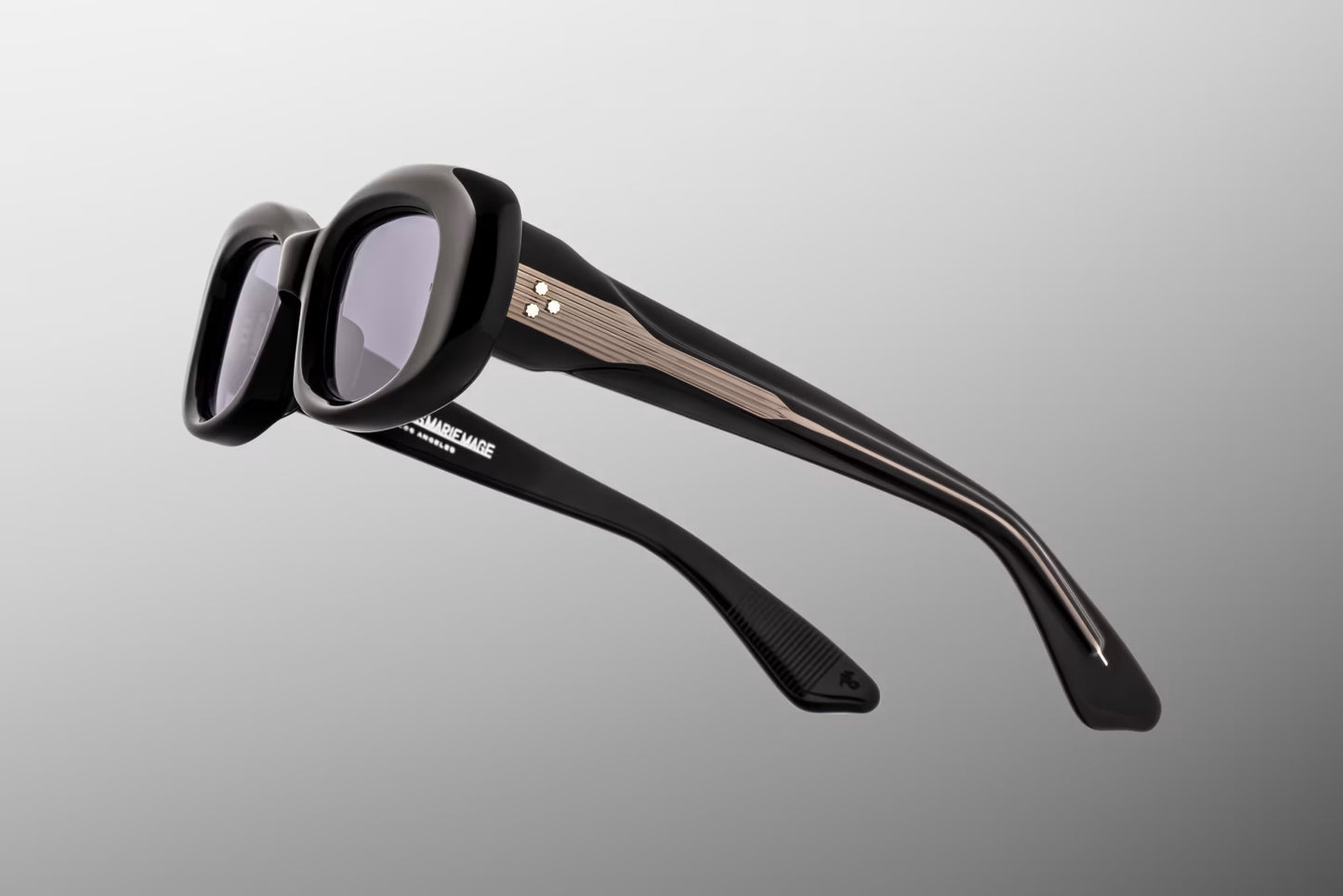 Close-up side detail of Jacques Marie Mage Ann Raven showing engraved wirecore, custom 7-barrel hinge and layered acetate temples
Macro side view of JMM Ann Raven sunglasses highlighting premium hardware and temple construction