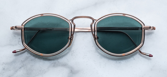 Distinguished titanium spectacles with soft lens shape, featuring a distinct acetate rim insert, unique bridge construction, and hand-painted epoxy temple tips.
ROSE GOLD 100% BETA TITANIUM FRAME WITH PINK CURED CELLULOSE ACETATE INSERTS AND GREEN LENSES.
Limited production of 100 pieces. Handcrafted in Japan. Size 47/26