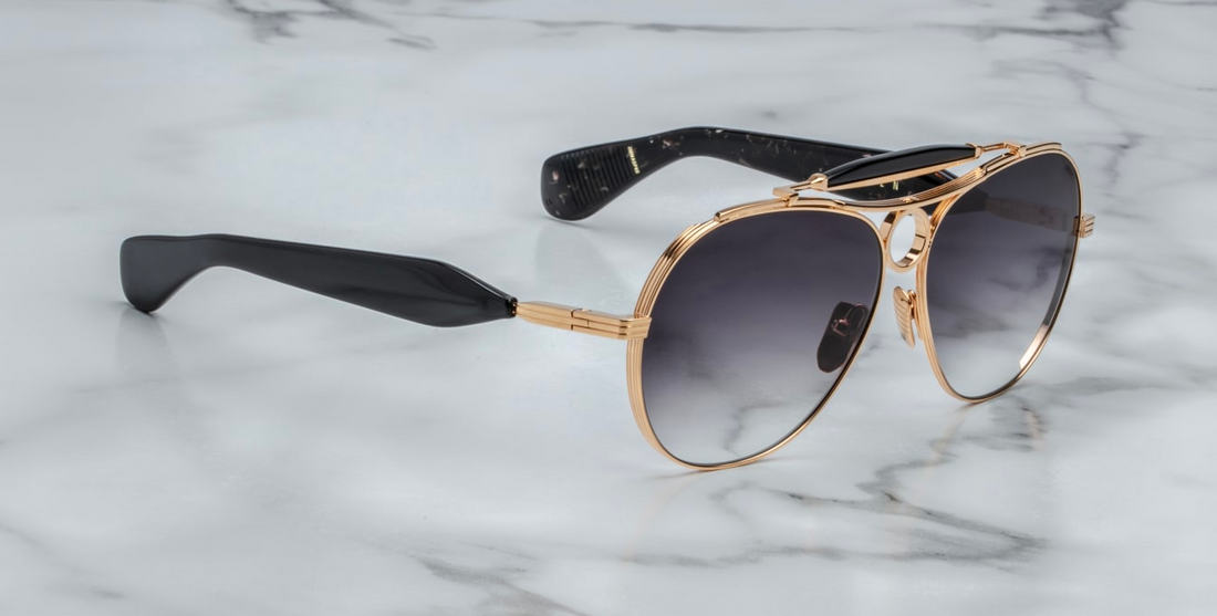Jacques Marie Mage Aspen in Gold/Black viewed from the side showing detailed hinge and mixed material design
