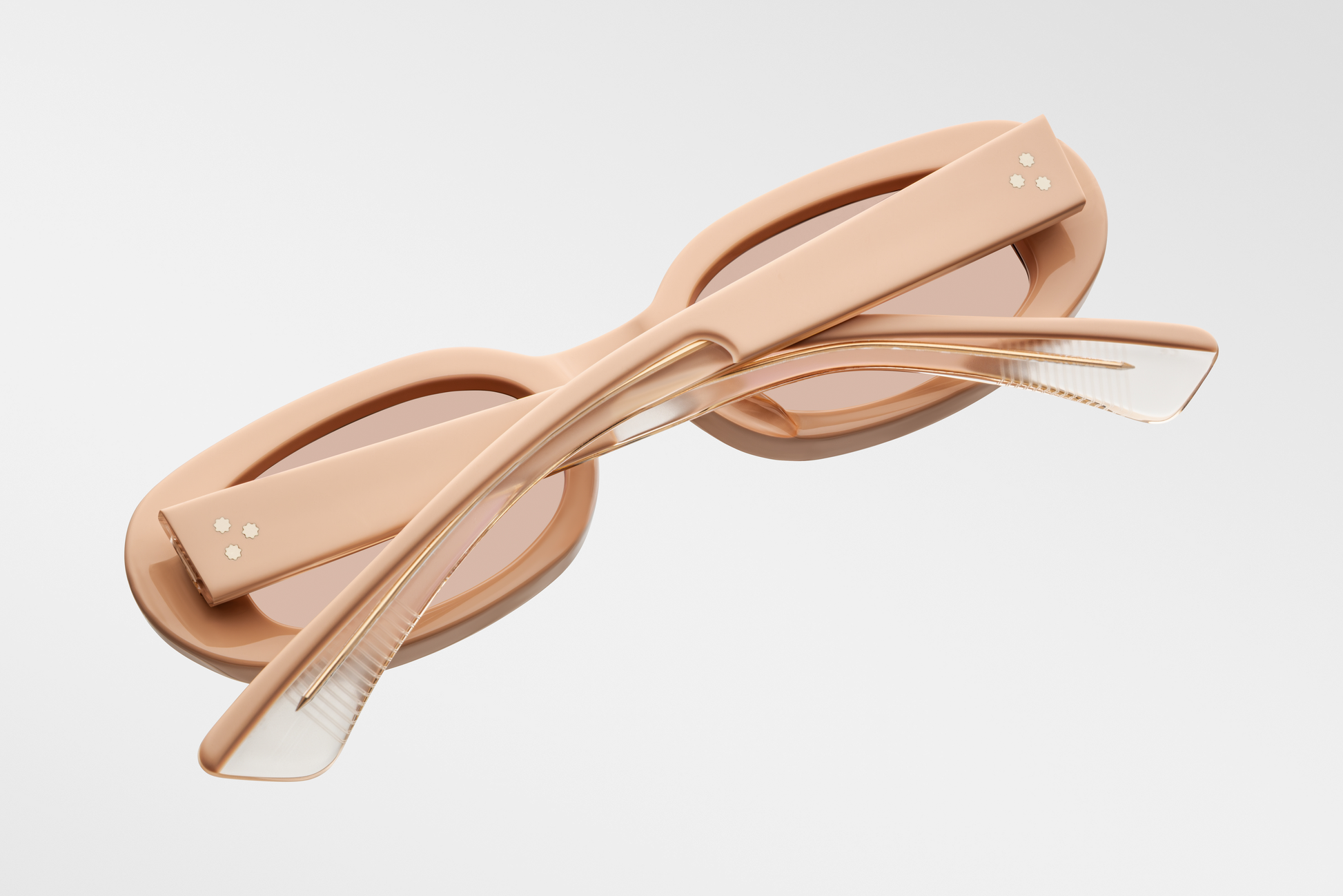 Close-up side view of Jacques Marie Mage Besset Dust Suede temple—8 mm cured matte orange‑peach cellulose acetate, light-gold arrowhead pin, light-gold lever wirecore, and tension‑secured 7‑barrel hairline‑engraved hinge