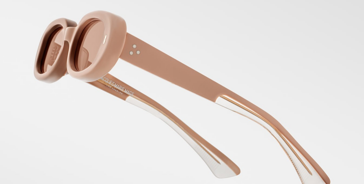 Close-up side view of Jacques Marie Mage Besset Dust Suede temple—8 mm cured matte orange‑peach cellulose acetate, light-gold arrowhead pin, light-gold lever wirecore, and tension‑secured 7‑barrel hairline‑engraved hinge.