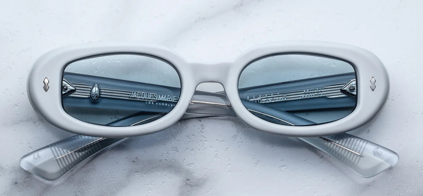 Front view of Jacques Marie Mage Besset Suede sunglasses in matte pastel blue acetate. Oval, ’90s‑inspired frames with silver wirecore and arrow‑head pin detail.