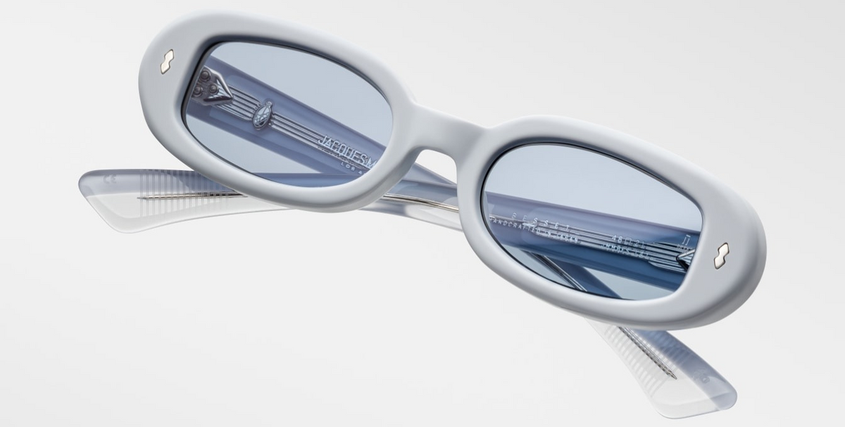 Angled view emphasizing Besset Sky Suede’s mode‑blue Armorlite lenses with backside AR coating, matte pastel‑blue frame, limited‑edition texture and refined minimalist ’90s styling