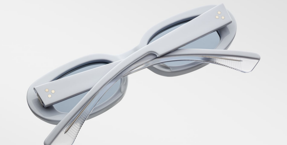 Angled view emphasizing Besset Sky Suede’s mode‑blue Armorlite lenses with backside AR coating, matte pastel‑blue frame, limited‑edition texture and refined minimalist ’90s styling