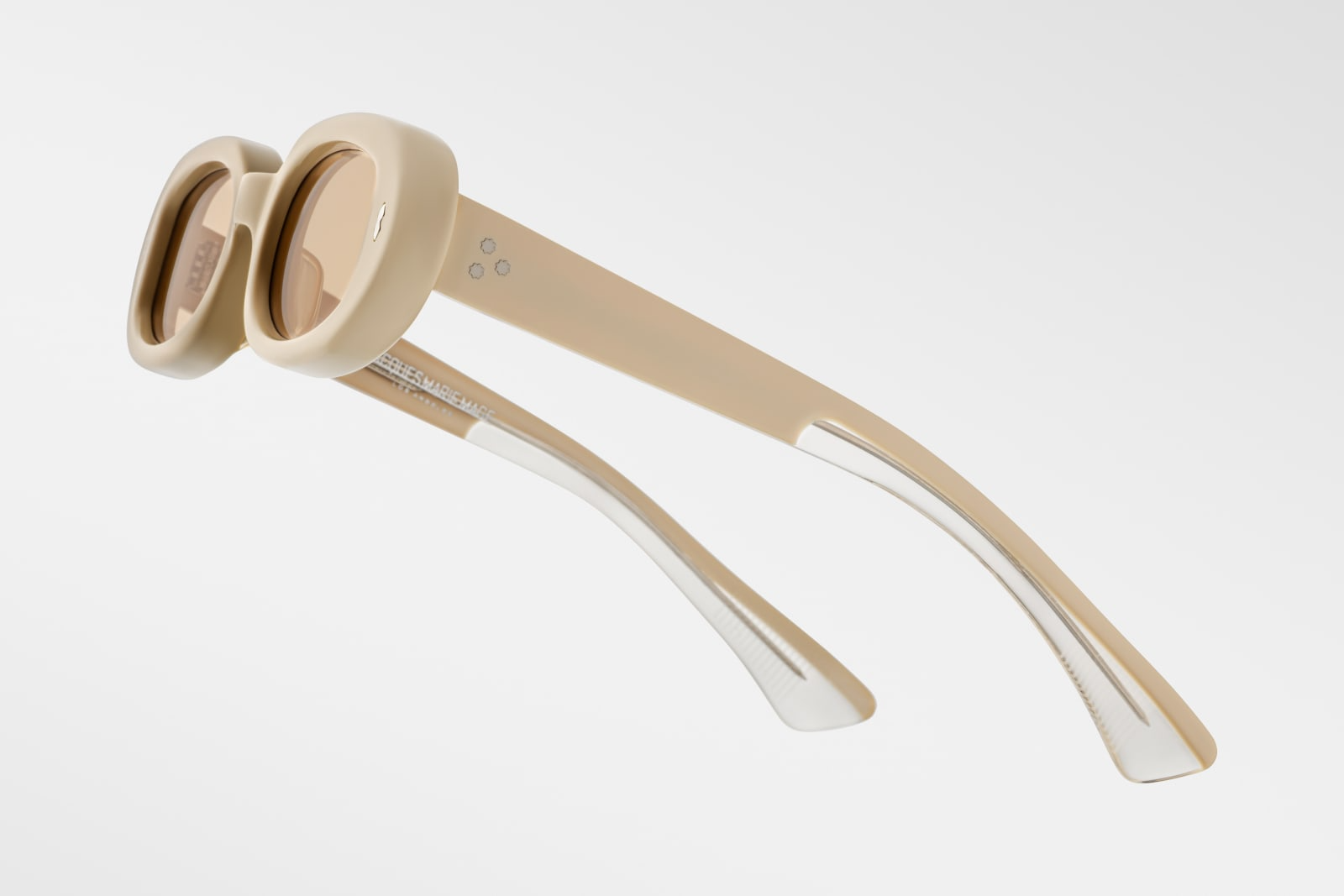 Close-up side view of Jacques Marie Mage Besset Sun Suede temple—8 mm cured yellow cellulose acetate, custom double-laminated temple, silver lever wirecore, tension-secured 7-barrel hinge, and signature arrowhead rivets.