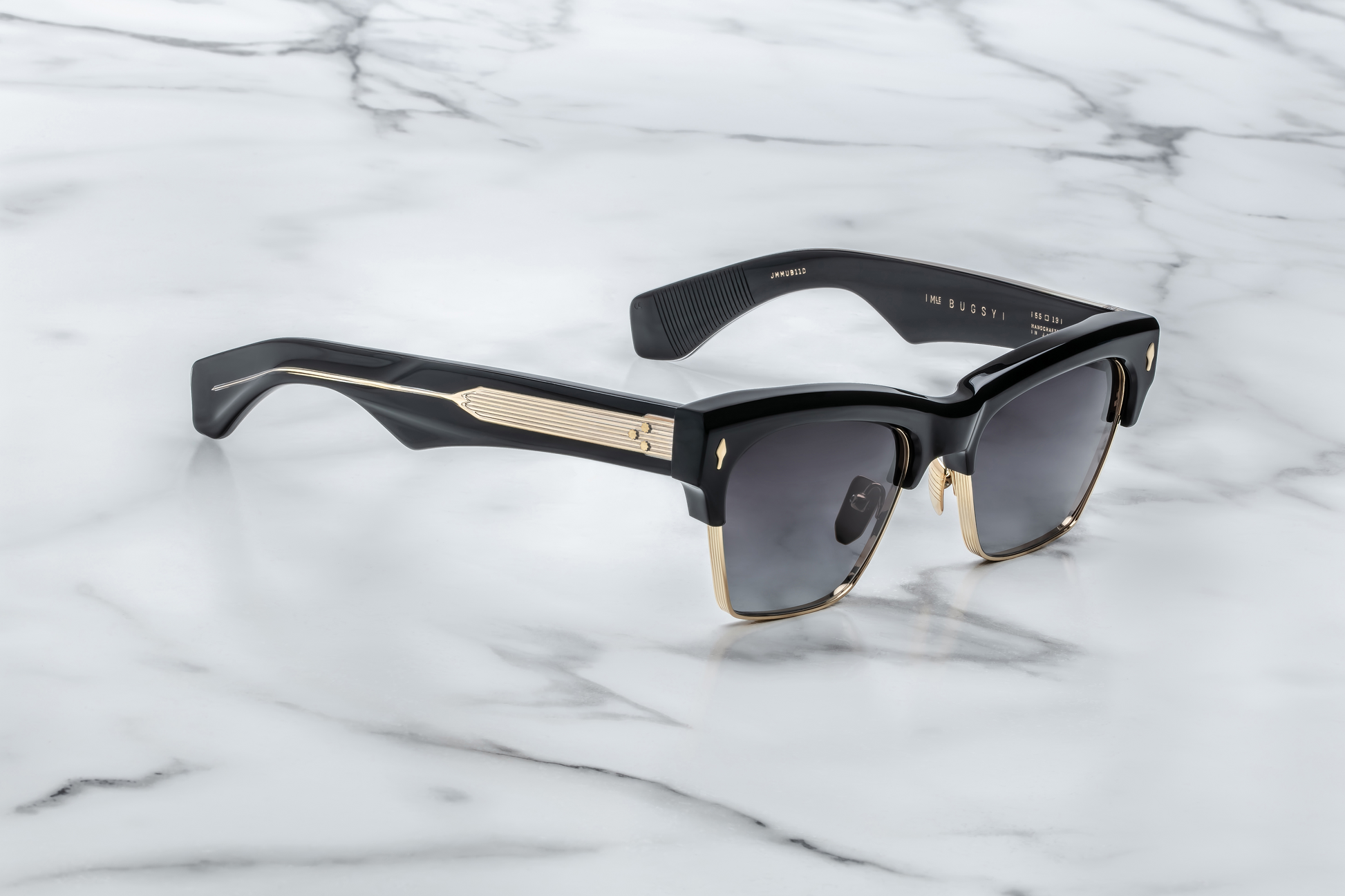 Side profile of Bugsy Eclipse 2 showing black acetate temple with exposed dark‑gold wirecore, light‑gold tension‑secured custom 7‑barrel hinge, and refined beta titanium frame construction.