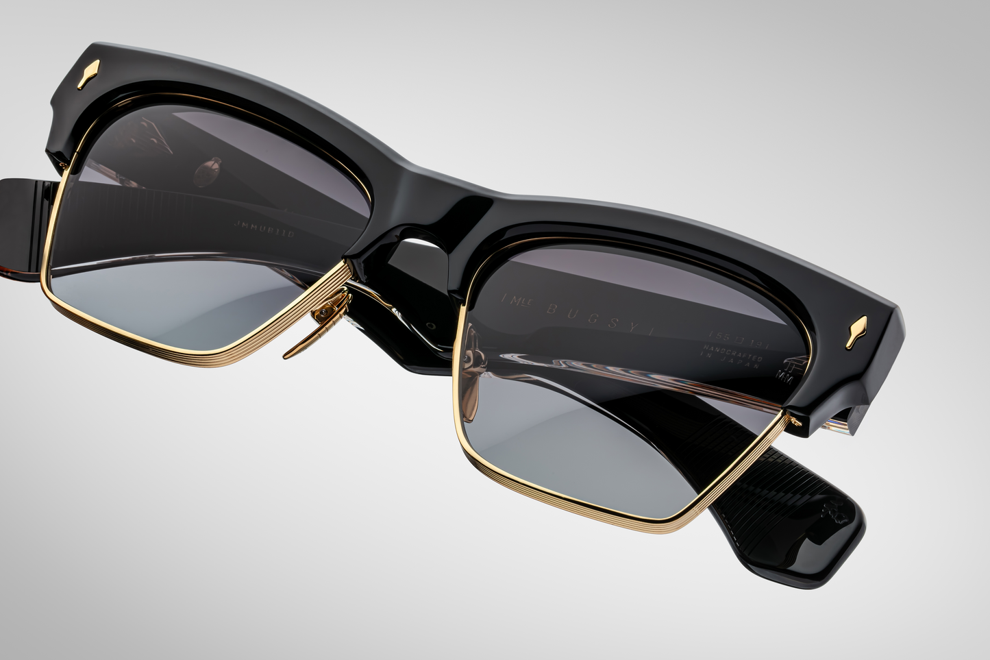 Top-down view of Bugsy Eclipse 2 highlighting medium fit frame, sculptural thick black acetate brow blending into sleek dark‑gold titanium lens rim with seamless acetatemetal integration.
