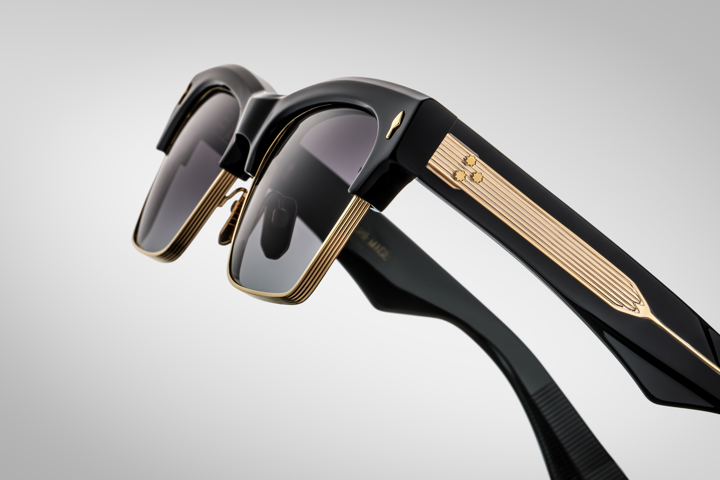 Side profile of Bugsy Eclipse 2 showing black acetate temple with exposed dark‑gold wirecore, light‑gold tension‑secured custom 7‑barrel hinge, and refined beta titanium frame construction.