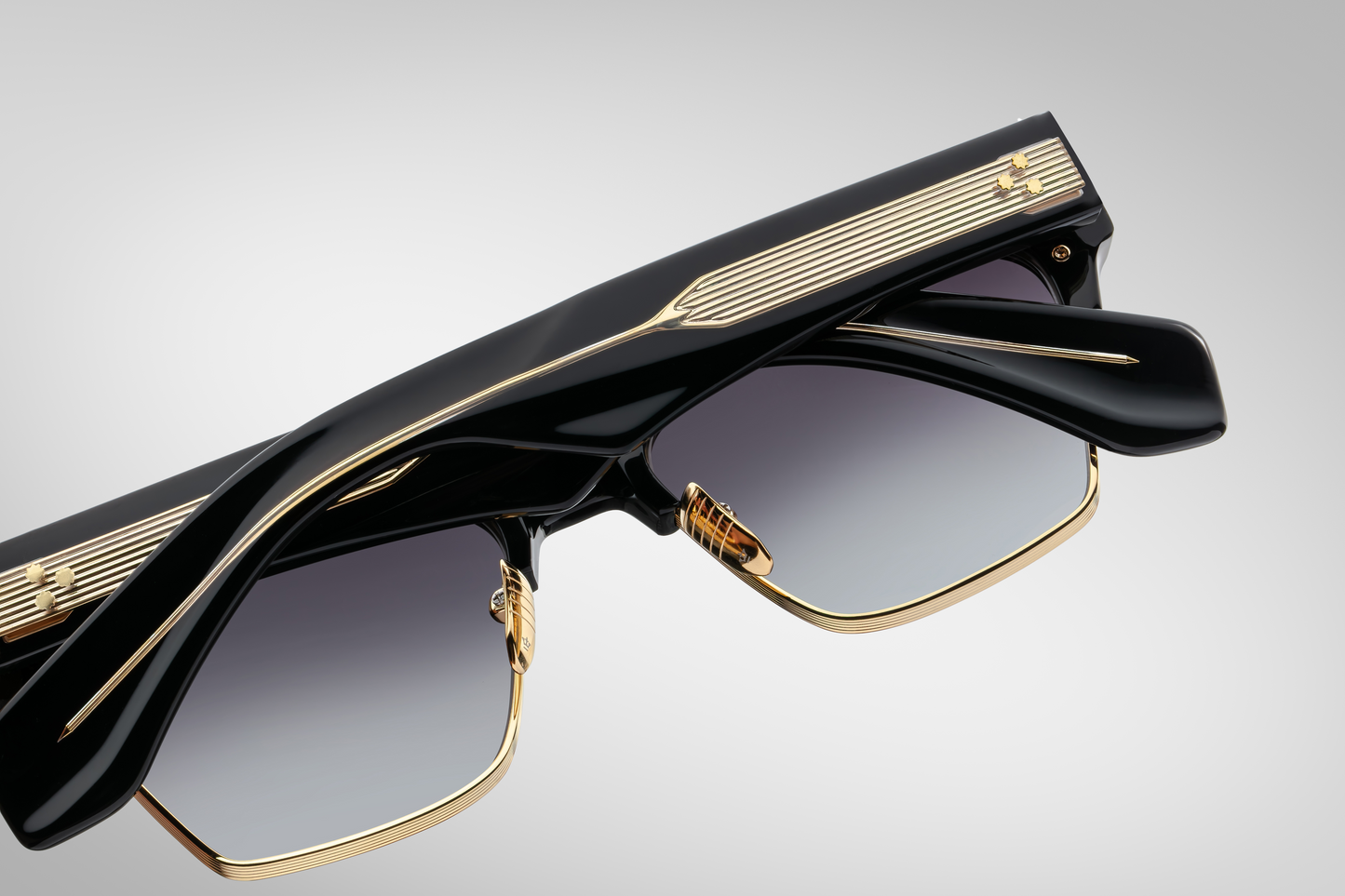 Back view of Bugsy Eclipse 2 displaying jet gradient CR‑39 lenses with backside anti‑reflective coating, 100% UV protection, and the premium combination of black cured acetate and dark‑gold beta titanium frame