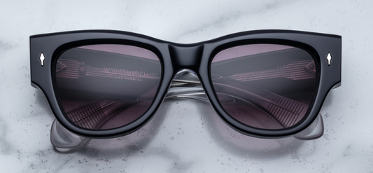 Side profile of Jacques Marie Mage Chelsea sunglasses in Skye, featuring sculpted paddle temples with exposed sterling silver cantilever wirecore, engraved detailing, and signature arrowhead front pin. Handcrafted in Japan with 10mm double-laminated pink cellulose acetate frame and custom 7-barrel hairline hinges, offering a bold, sculptural silhouette. Autumn gradient CR39 lenses provide 100% UV protection and backside anti-reflective treatment