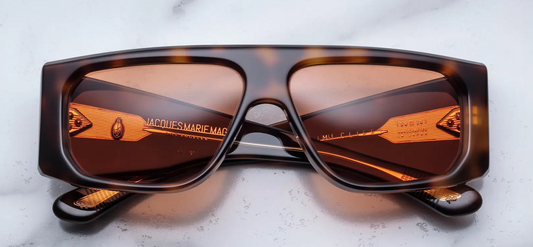 Front view of Jacques Marie Mage Cliff Havana 7 sunglasses, featuring a bold, square frame in a rich, deep Havana acetate finish. The frame is wide with a sculpted, angular design that creates a strong, distinctive look. The dark lenses offer a sleek contrast to the warm tones of the frame