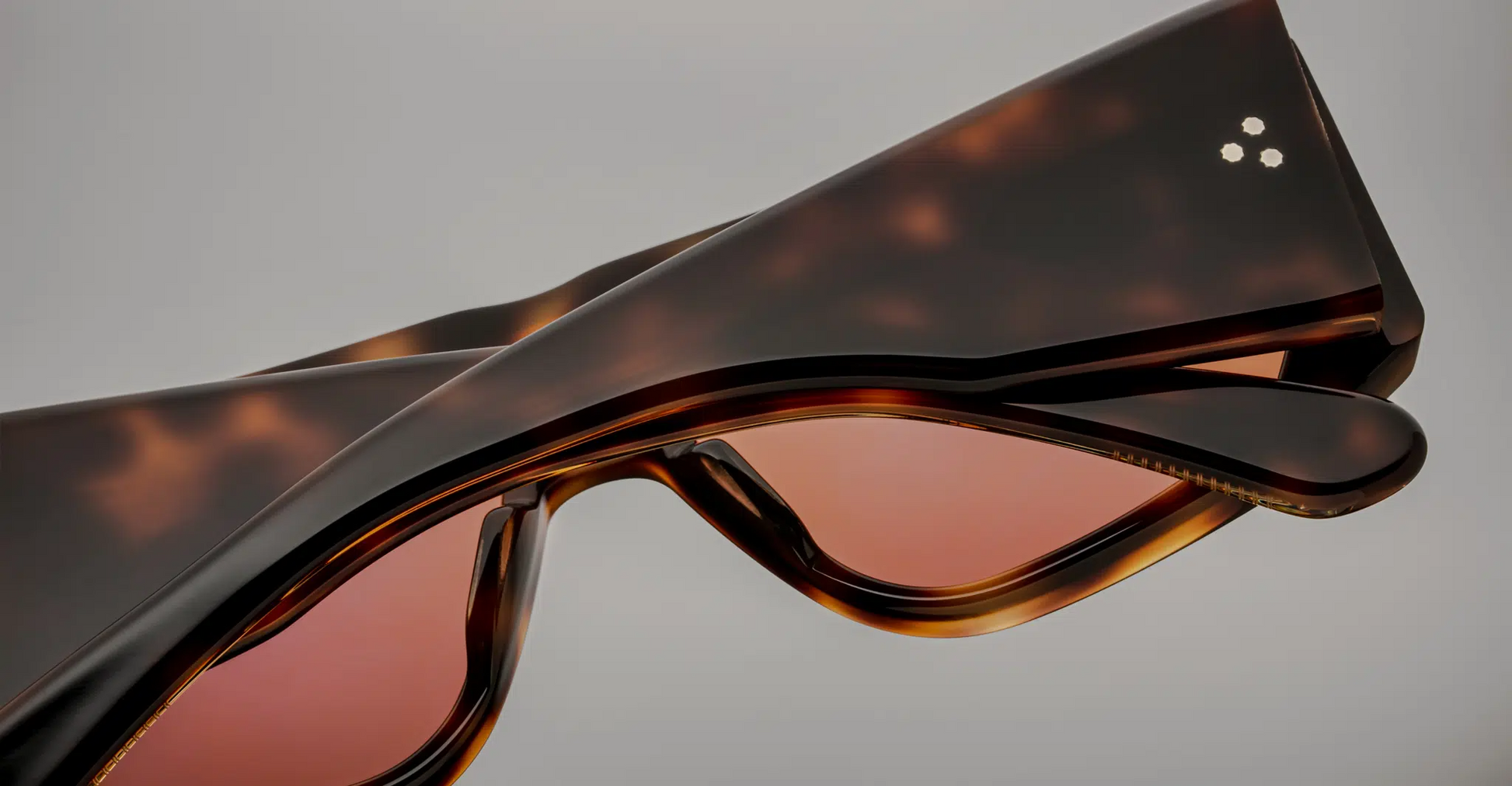 Close-up of the temples of Jacques Marie Mage Cliff Havana 7 sunglasses, showcasing the fine gold-tone metal detailing and the premium Havana acetate. The temple tips are smoothly tapered, and the craftsmanship is precise, contributing to a sophisticated and elegant design