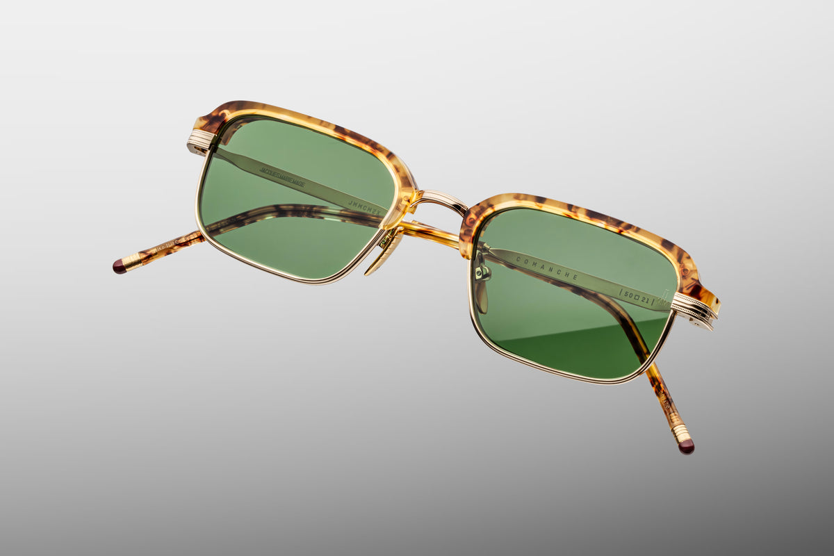 Close-up detail of the Jacques Marie Mage Comanche frame, showcasing the custom monoblock hinges, coined-edge titanium rim wire, and hand-painted epoxy tips.