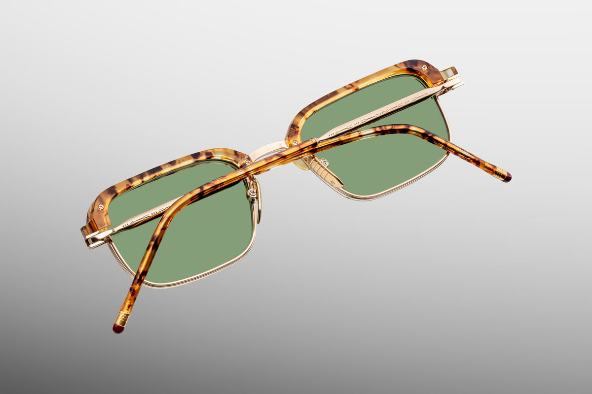 Back view of Jacques Marie Mage Comanche sunglasses in Vintage Tort with arms folded, showing the custom light gold titanium temples, custom monoblock hinges, and the inner tortoise acetate rim.