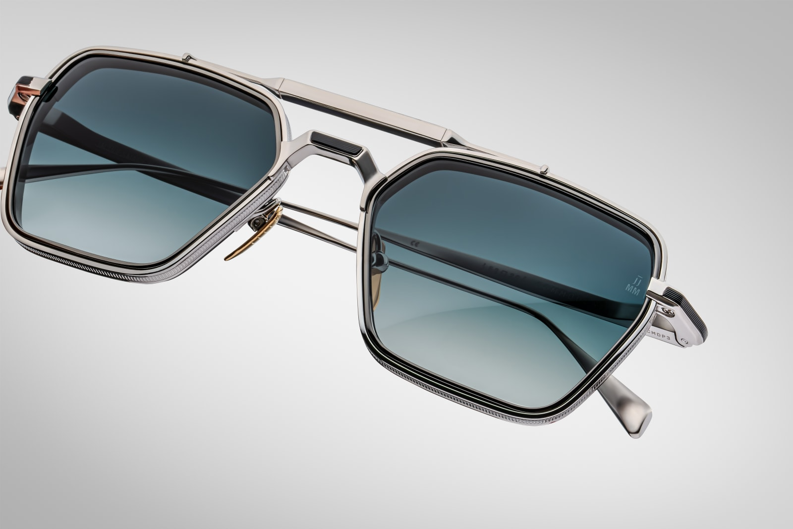 Close-up of Jacques Marie Mage Commodore sunglasses in Pacific highlighting fine acetate craftsmanship, metal detailing, and polished lens edges, available at WINK Optometrists.