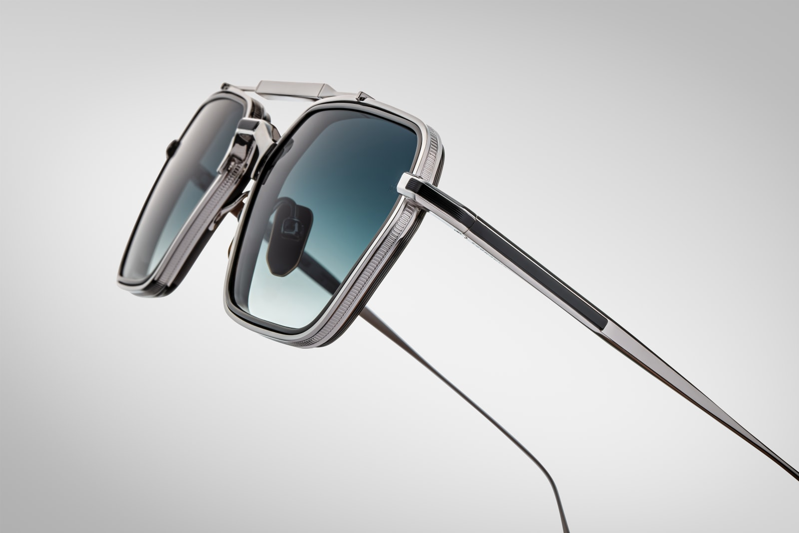 Temple detail of Jacques Marie Mage Commodore in Pacific showing engraved JMM emblem, precision hinge design, and layered blue acetate, available at WINK Optometrists.